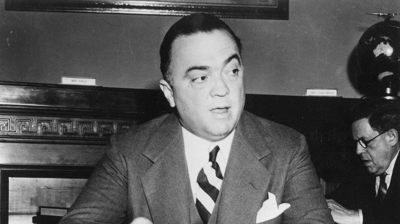 J Edgar Hoover, directeur du FBI, homme en costume devant un globe