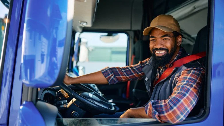 Conducteur de camion souriant dans la cabine du semi-remorque