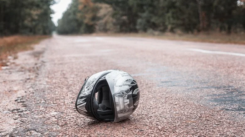 Casque de moto au sol sous la pluie