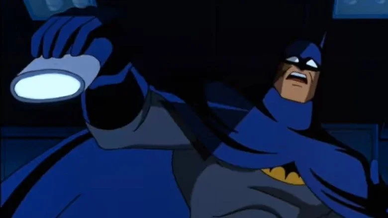 Batman tenant une lampe torche avec un regard horrifié