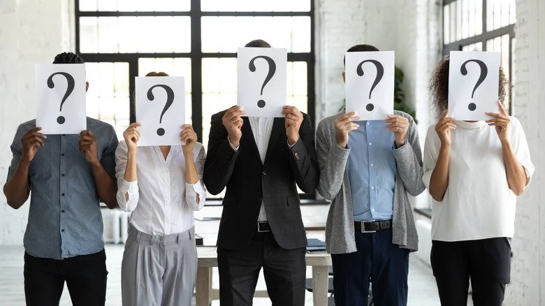 Personnes tenant des points d'interrogation