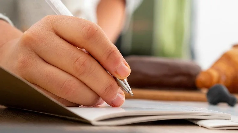 Une main écrivant avec un stylo