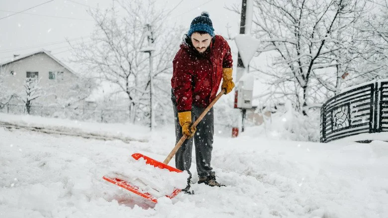 Un homme utilisant une pelle à neige en hiver
