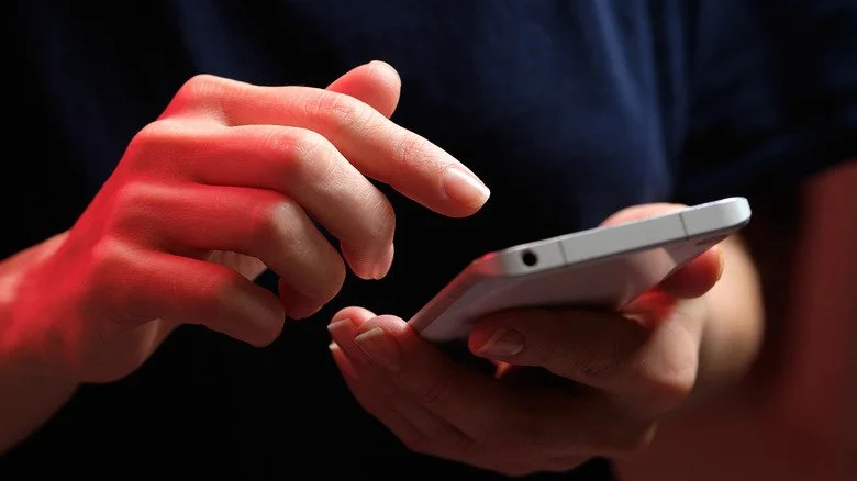 Personne tapant sur l'écran de son téléphone portable