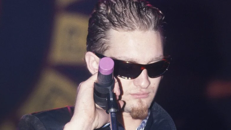 Layne Staley tenant un microphone et regardant vers le bas