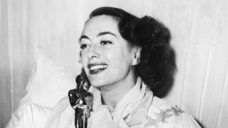 Joan Crawford posant au lit avec son Oscar pour Mildred Pierce