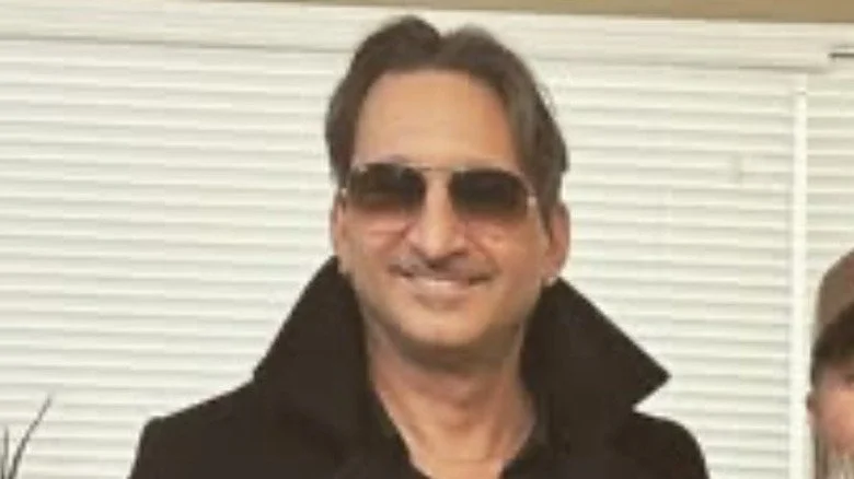 Johnny Bacolas souriant avec des lunettes de soleil