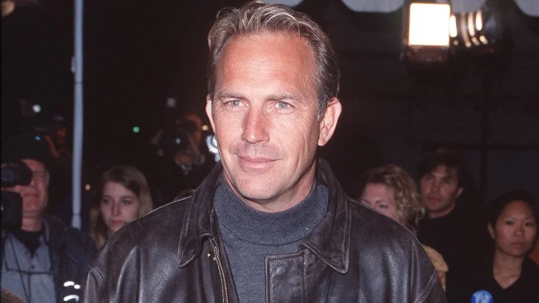Kevin Costner souriant en veste en cuir