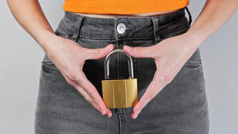 Femme tenant un cadenas devant son bassin