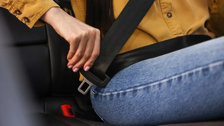 Gros plan sur une main attachant une ceinture de sécurité