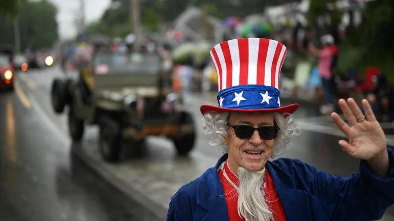Personne vêtue d’un costume patriotique devant un défilé flou