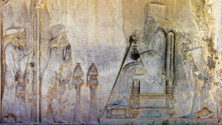 Bas-relief mésopotamien représentant des personnes devant un roi sur son trône