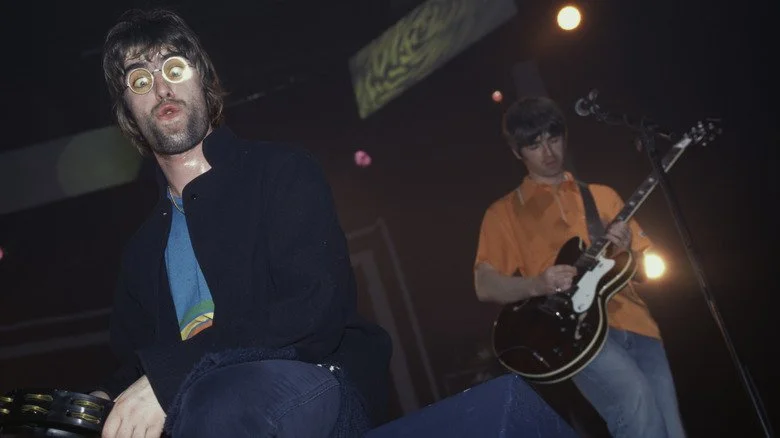 Liam et Noel Gallagher sur scène avec Oasis en 1996