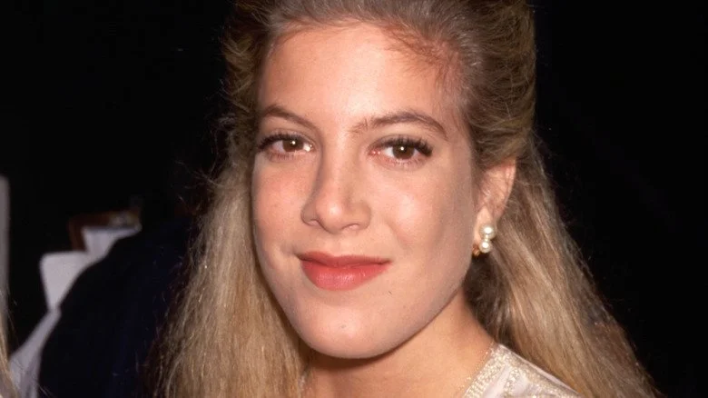 Tori Spelling souriant lors d'un événement des années 1990