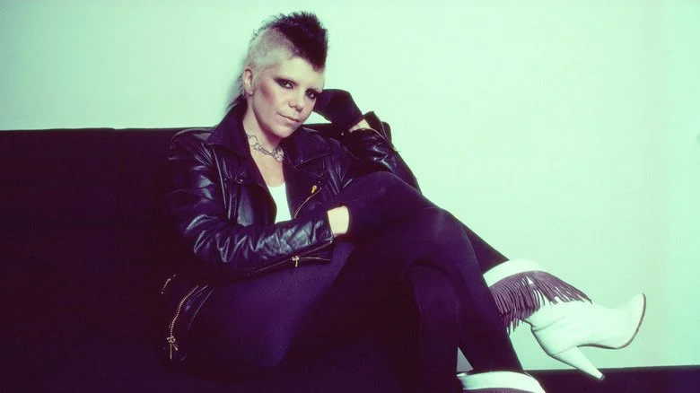 Wendy O. Williams assise sur un canapé en coulisses