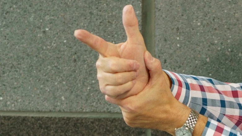 Un homme mimant un pistolet avec ses doigts