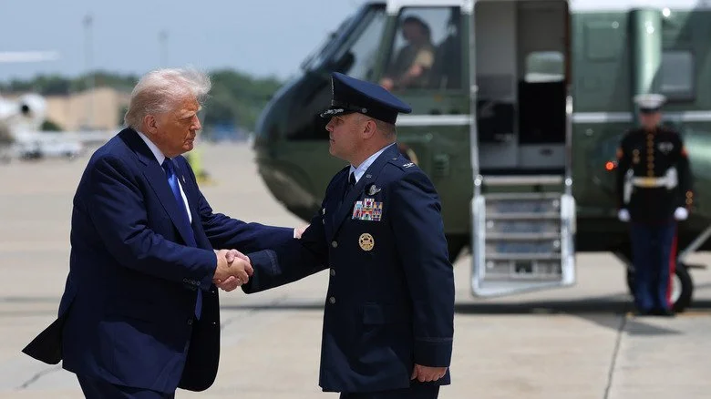 Donald Trump serrant la main de militaires devant un hélicoptère
