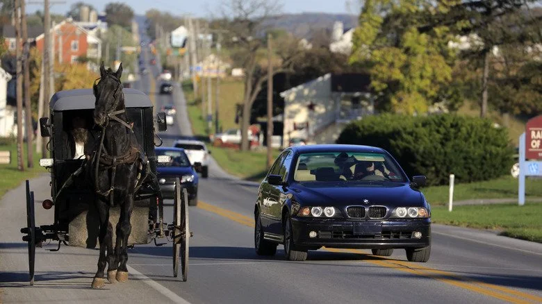 Carriole amish aux côtés d'une voiture