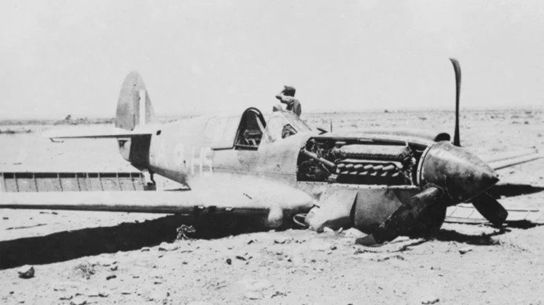 Un soldat allemand près d'un Curtiss Kittyhawk I écrasé en Afrique du Nord