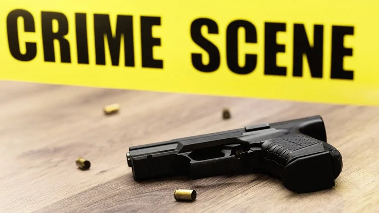 Pistolet avec douilles et ruban de scène de crime