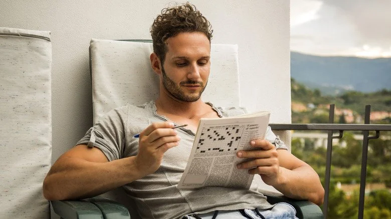 Un homme résolvant un mot croisé