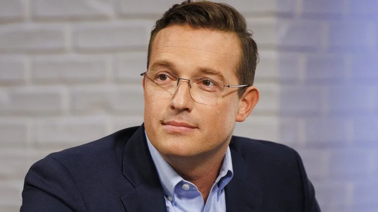 Benny Johnson en blazer regardant sur le côté