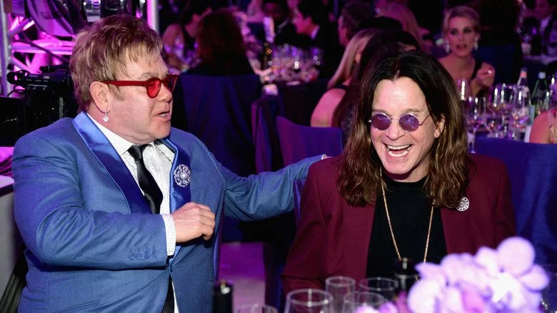 Elton John posant la main sur l'épaule de Ozzy Osbourne riant