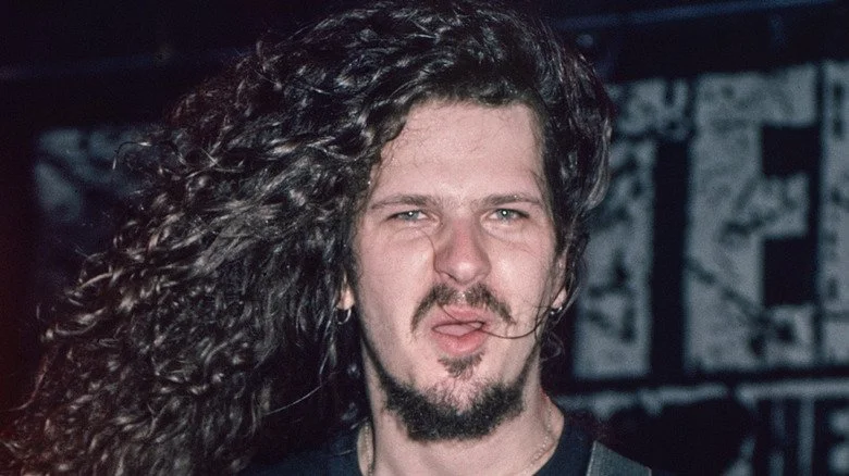 Dimebag Darrell Abbott jouant de la guitare et faisant une grimace à la caméra
