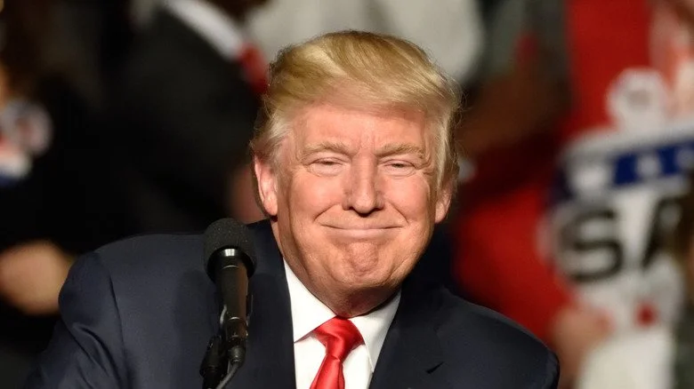 Donald Trump souriant à un pupitre