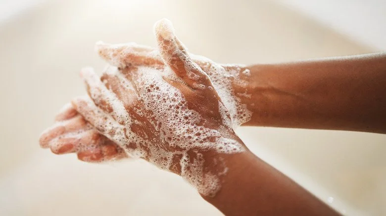 Mains couvertes de mousse de savon en gros plan
