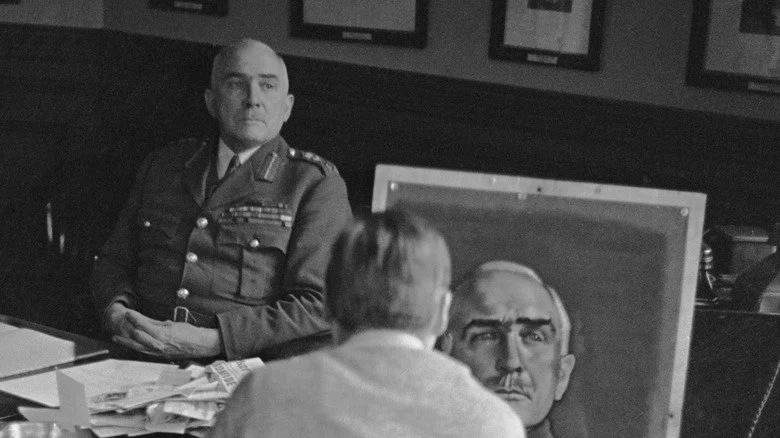 Edmund Ironside assis à son bureau pendant qu'un portraitiste le peint