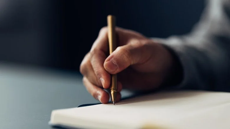 Une main écrivant avec un stylo