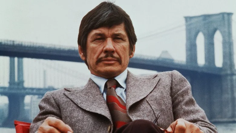 Charles Bronson assis sur une chaise en 1974