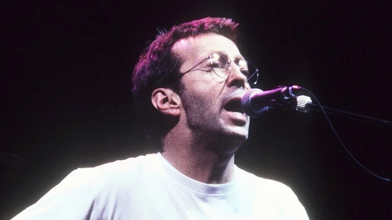 Eric Clapton chantant et jouant de la guitare sur scène dans les années 1990