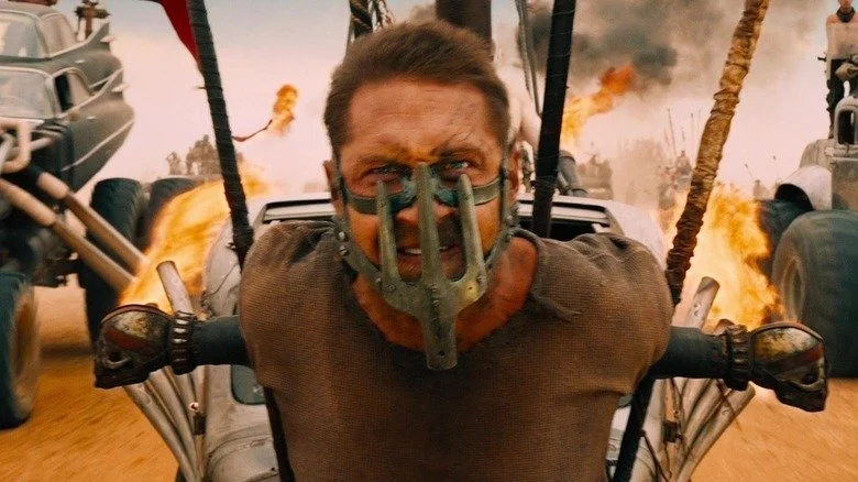 Tom Hardy's Max Rockatansky strapped to the front of a vehicle in Mad Max: Fury Road