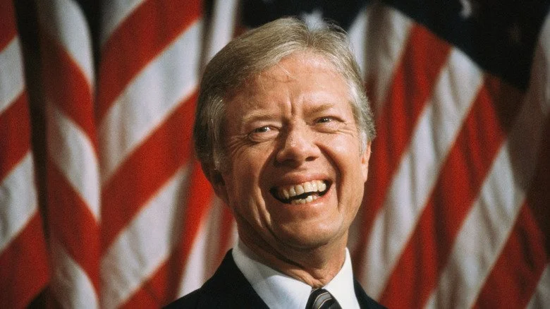 Jimmy Carter devant le drapeau américain, souriant