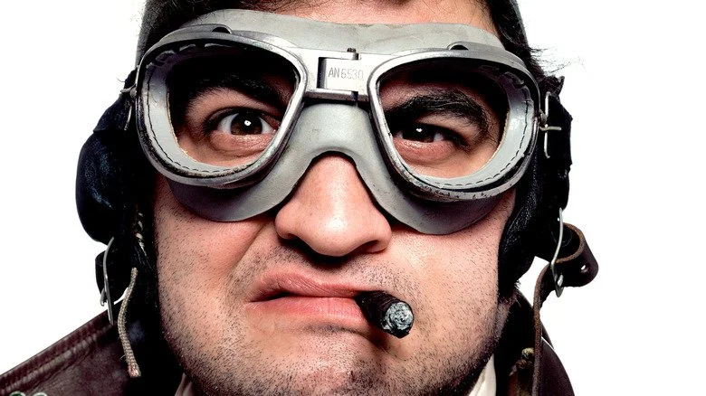 John Belushi avec lunettes de protection et un cigare