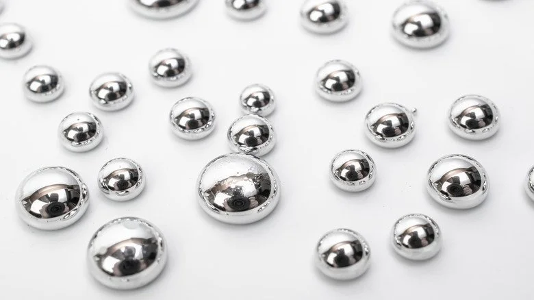 Gouttes de mercure sur une surface blanche