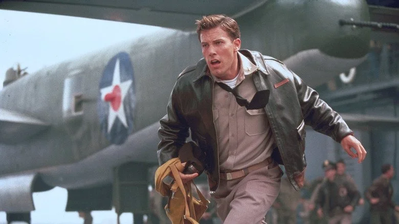 Ben Affleck courant dans une scène de Pearl Harbor, en uniforme kaki et blouson en cuir.