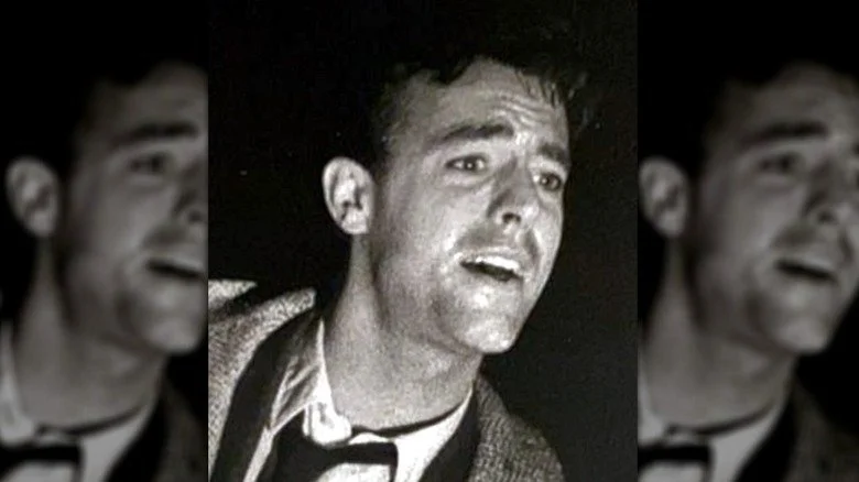 Peter Aykroyd en veste en tweed et cravate noire