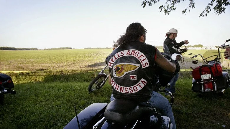 Membres des Hells Angels assis sur des motos dans un champ ouvert