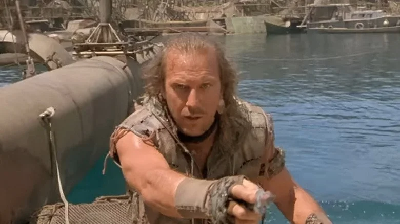 Le Marin joué par Kevin Costner pointant dans Waterworld