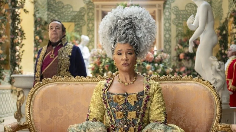 Queen Charlotte assise sur un canapé dans une scène de Bridgerton