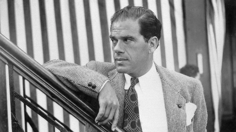 Frank Capra leans on a railing