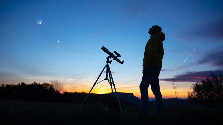 astronome debout près d'un télescope la nuit