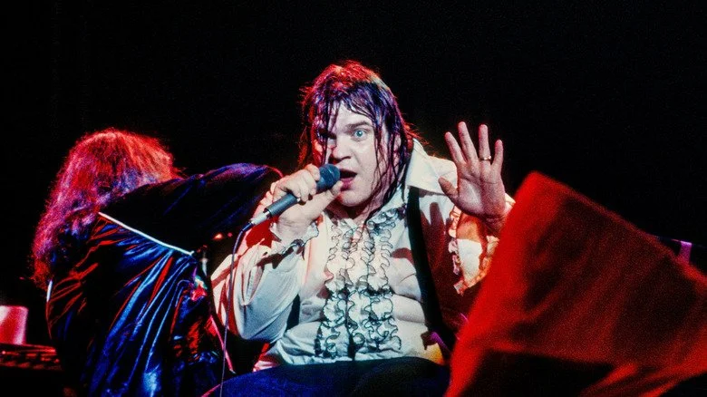 Meat Loaf sur scène, regardant vers le haut, portant une chemise de smoking
