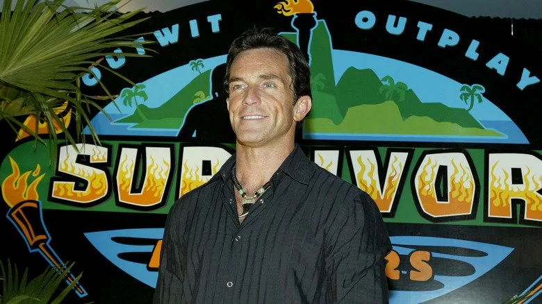 Jeff Probst devant le logo de Survivor