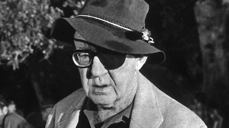 John Ford looks up from under his hat brim