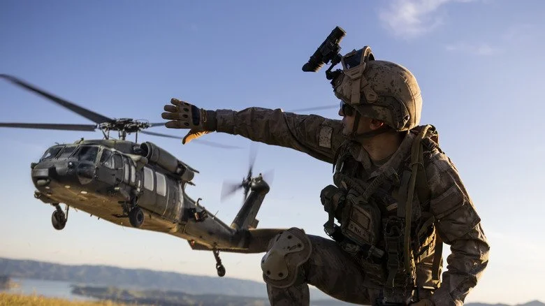 Soldier signalling helicopter during daytime