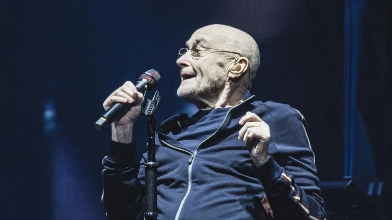 Phil Collins chantant avec un micro
